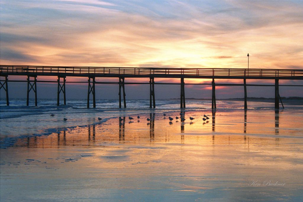 A pier overlooking a body of water at sunset