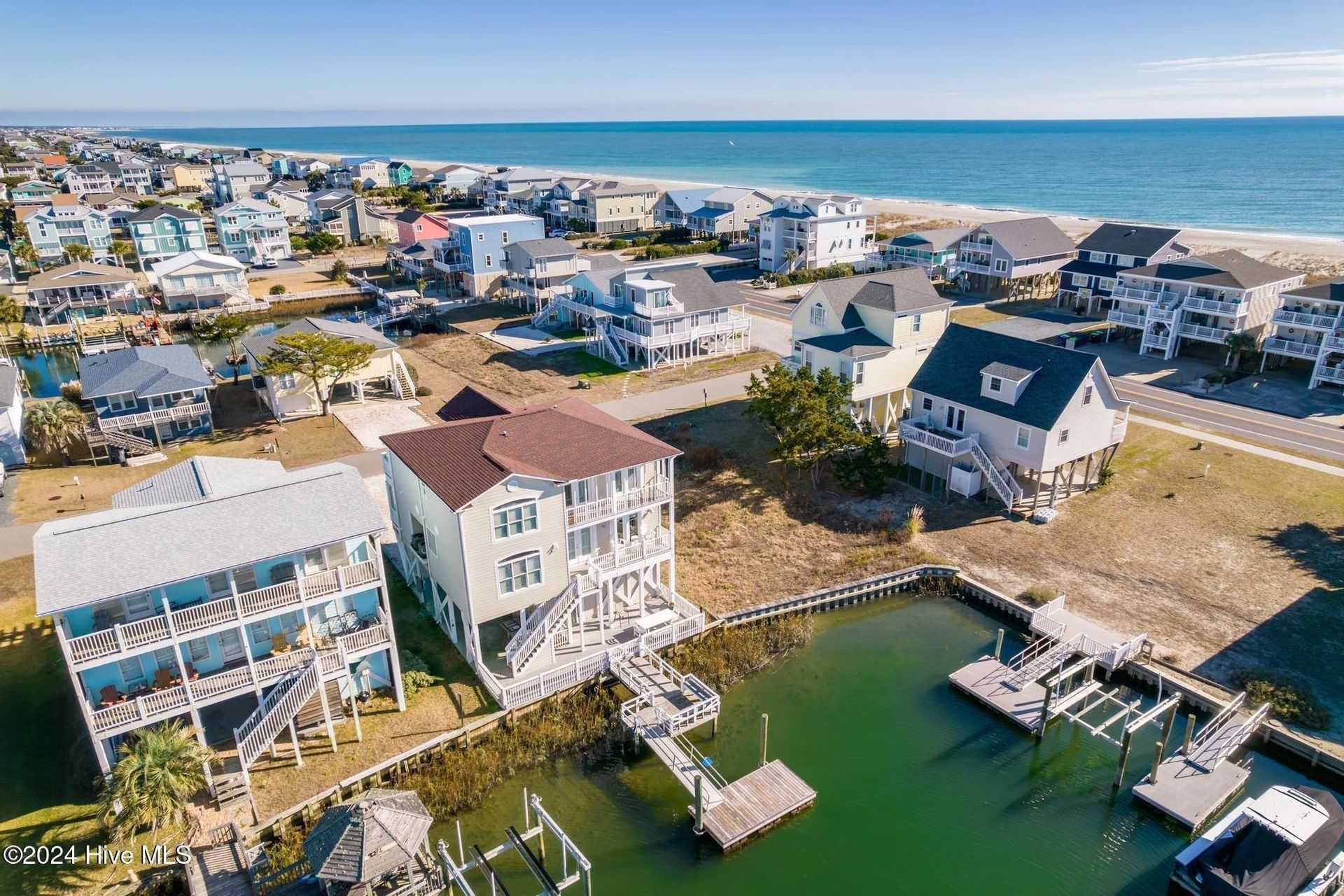 An aerial view of a beach with houses and a dock.