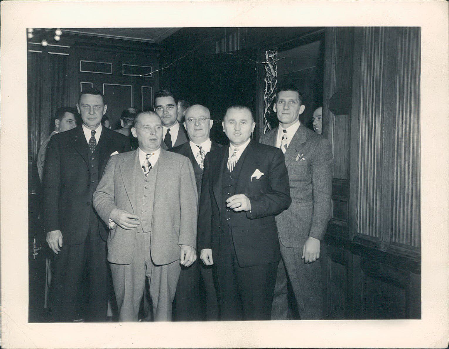 A group of men in suits pose for a photo