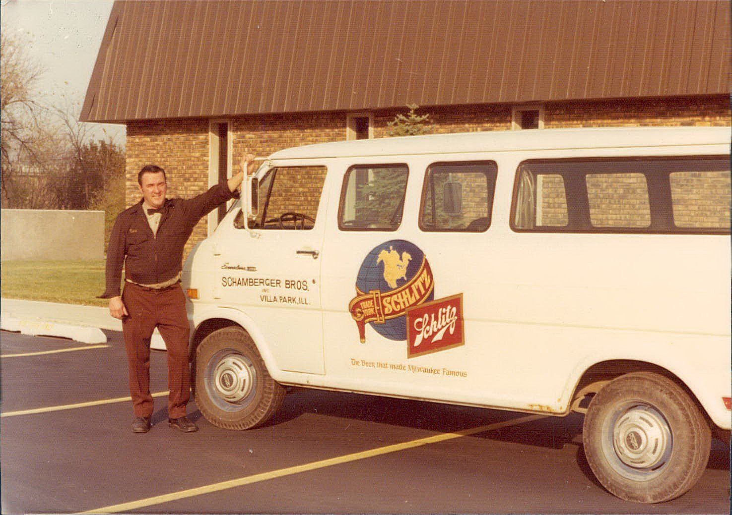 A man is standing next to a white van that says ' free roast ' on it