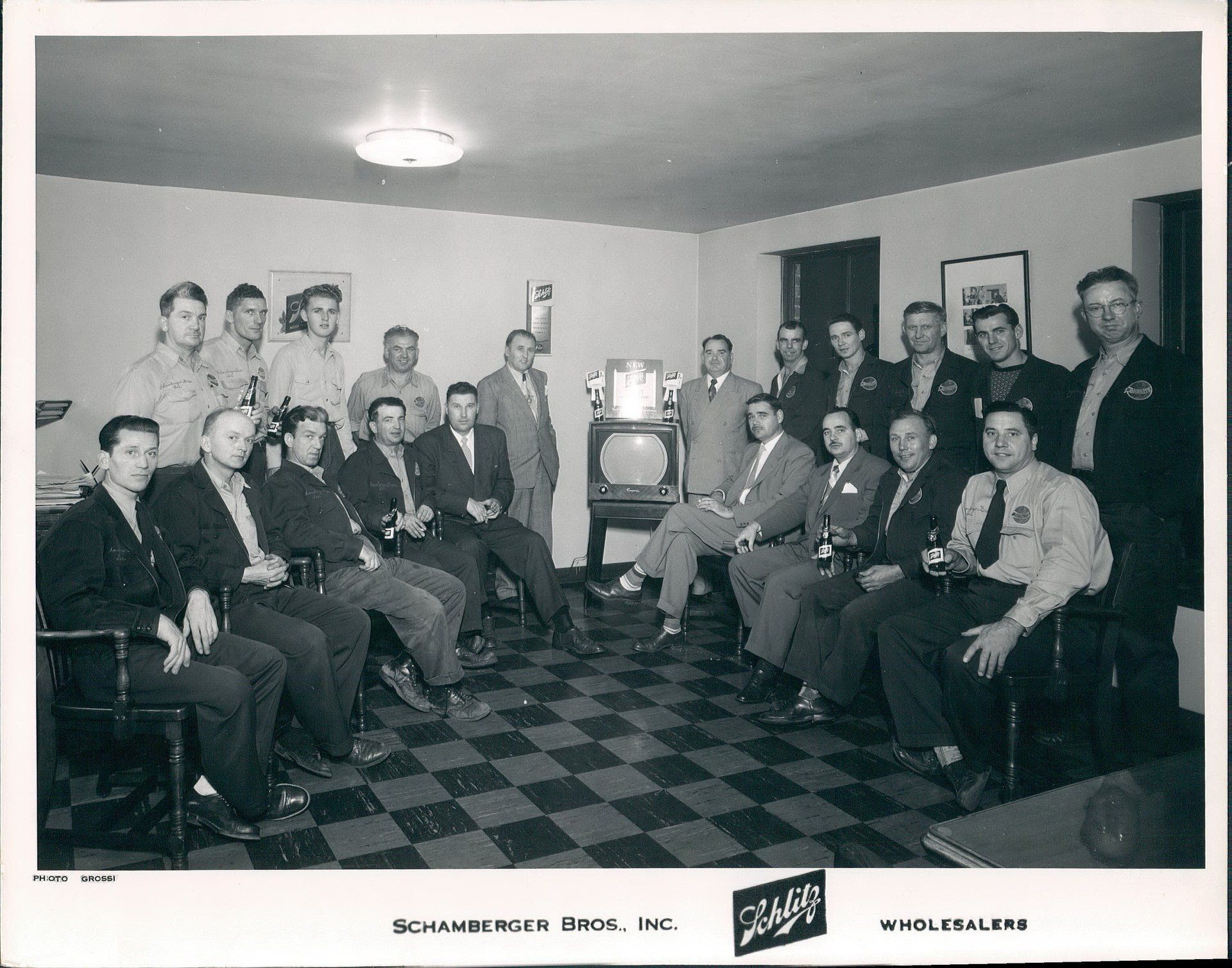 A black and white photo of a group of men sitting in chairs