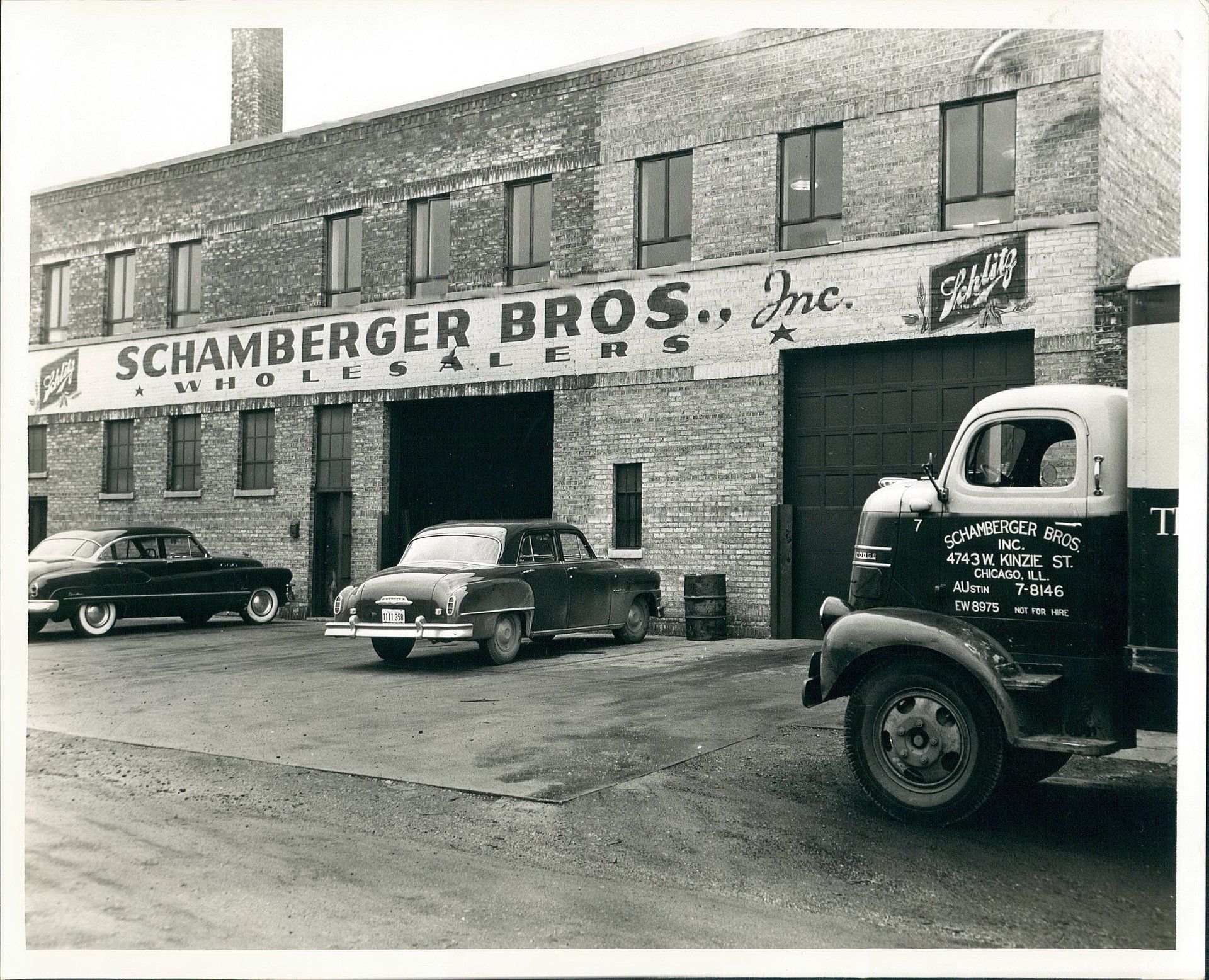 A truck is parked in front of a building that says schamberger bros