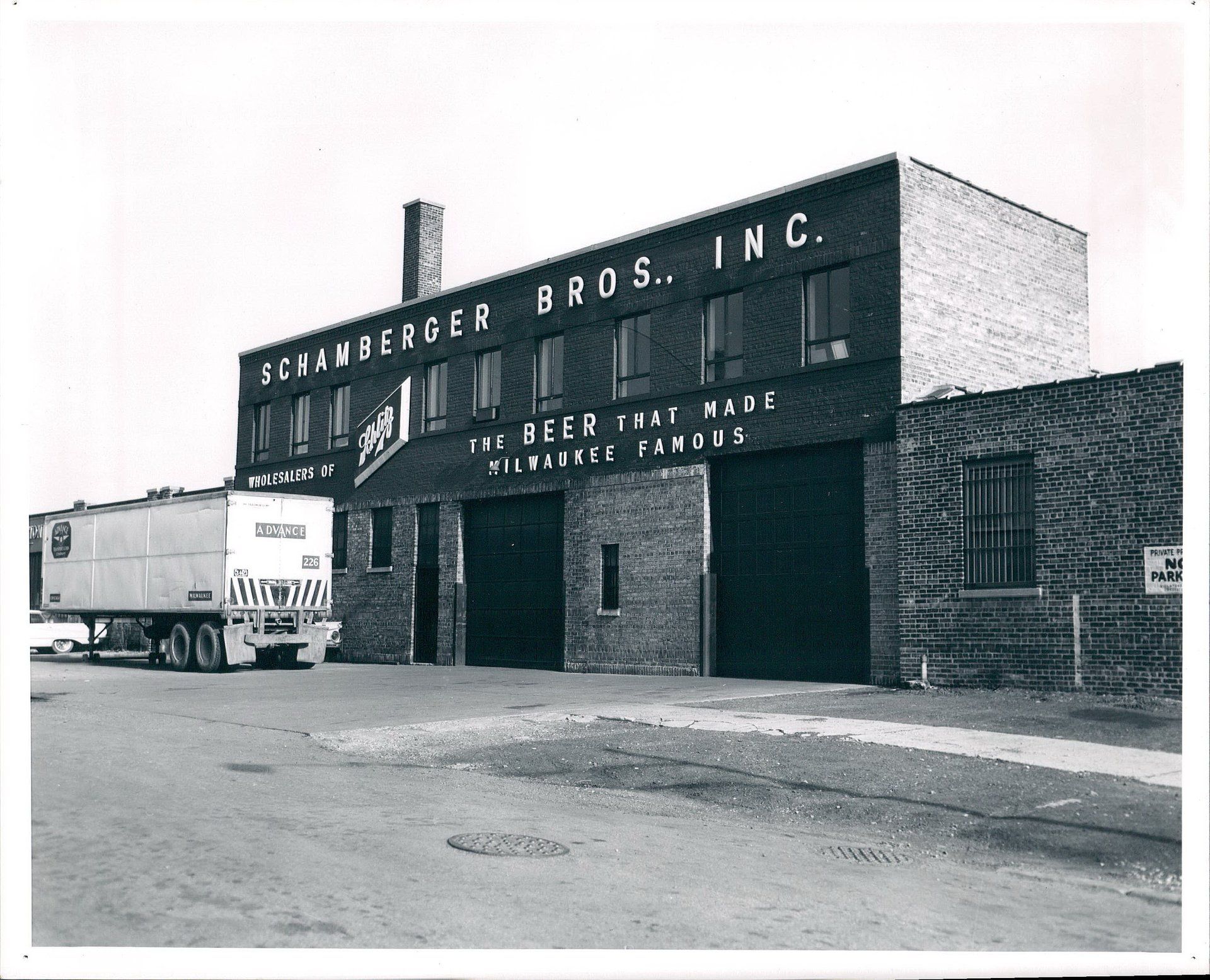 A truck is parked in front of a building that says schenberger bros. inc.