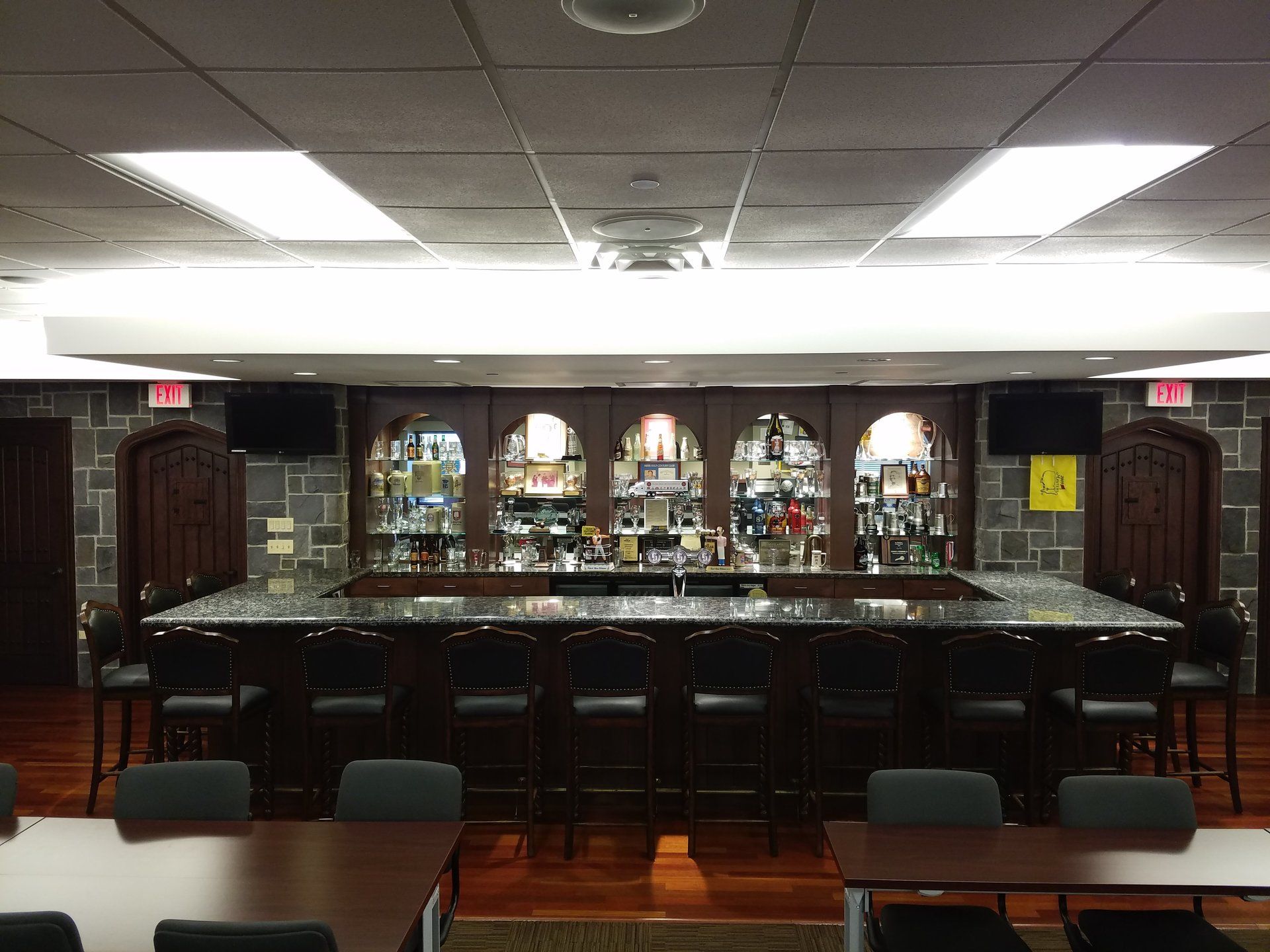 A large room with a bar and tables and chairs