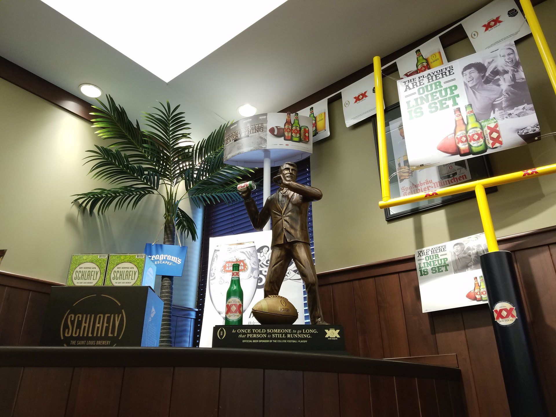 A statue of a man holding a football in a room with a sign that says schlafly