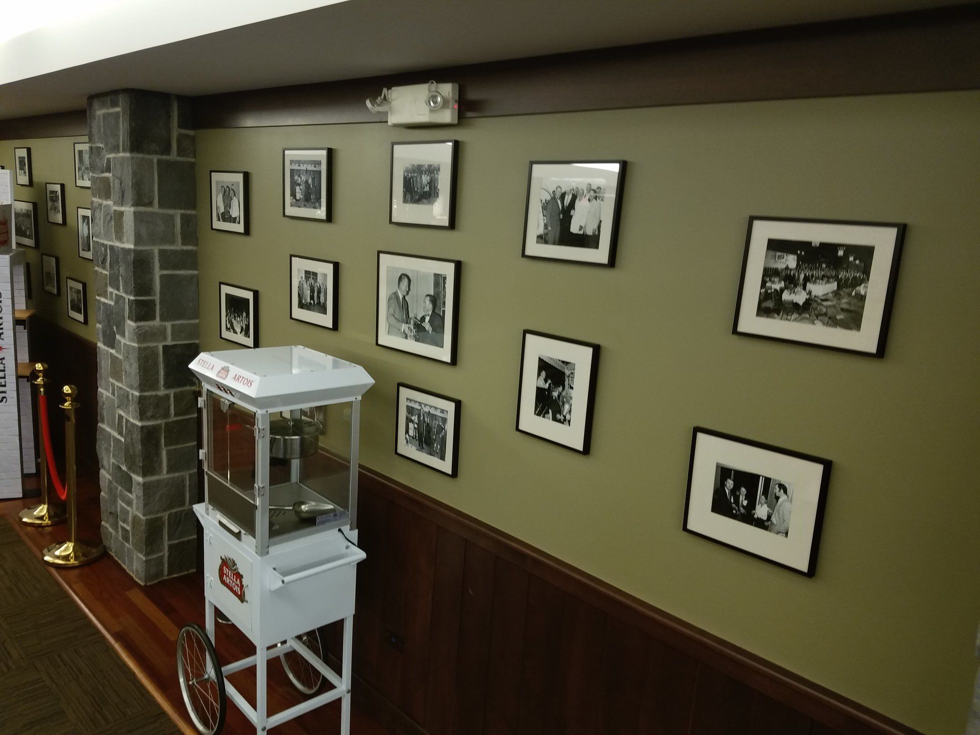 A popcorn machine in a hallway with pictures on the wall