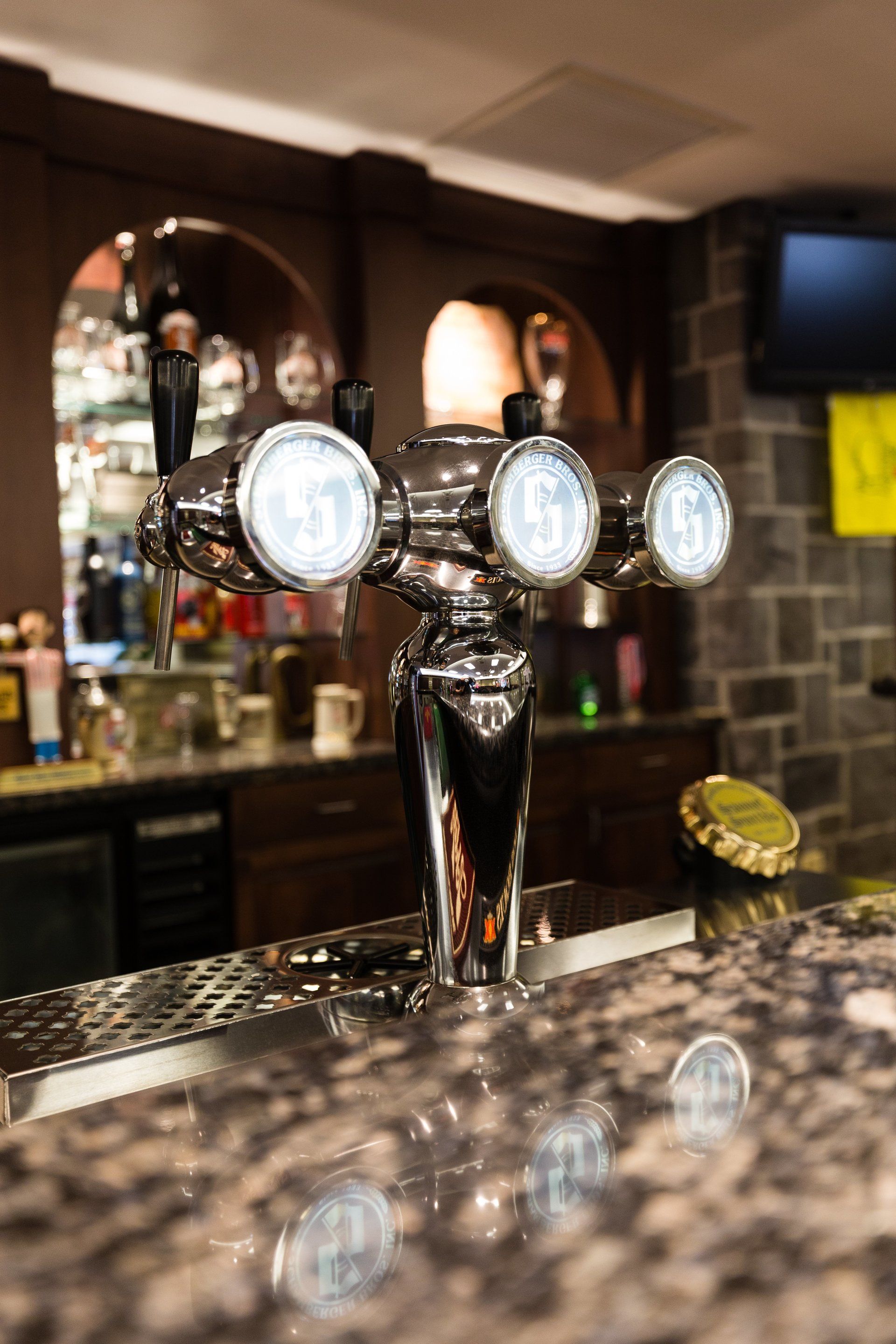 A close up of a beer tap on a counter in a bar.