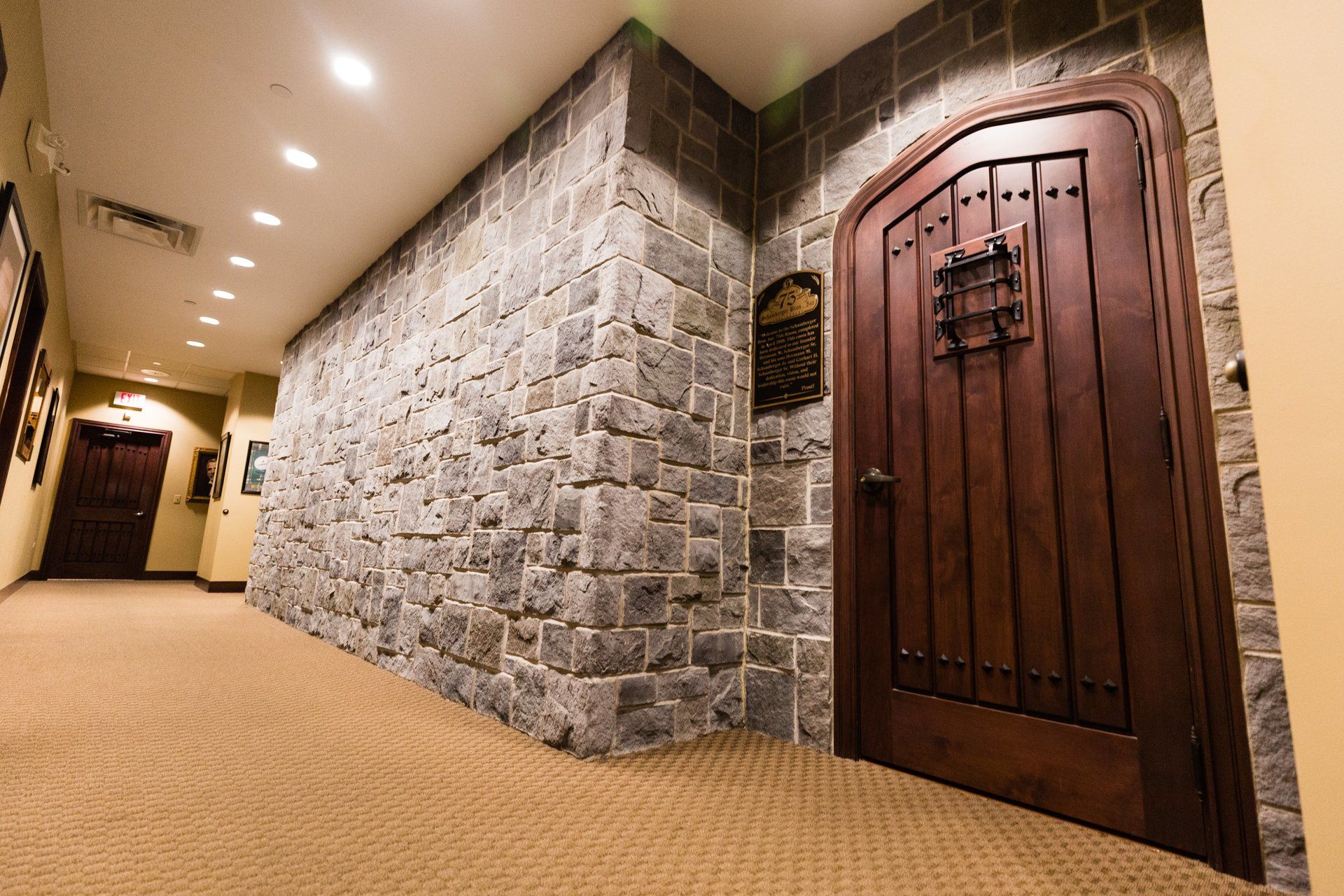 A hallway with a stone wall and a wooden door