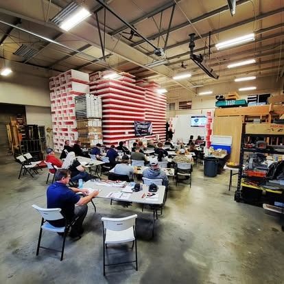 A group of people attending a seminar in an industrial warehouse,