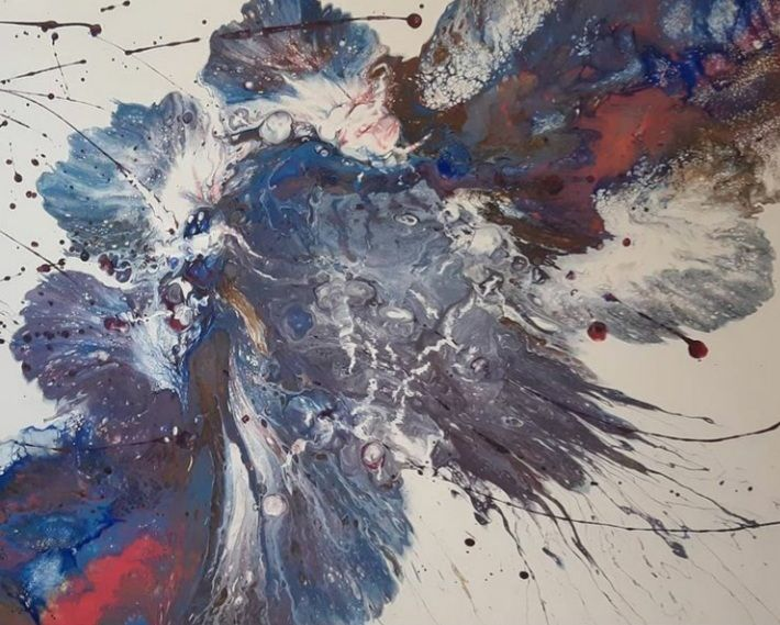 Abstract acrylic pour art with splashes of blue, white, red, and brown on a white background.