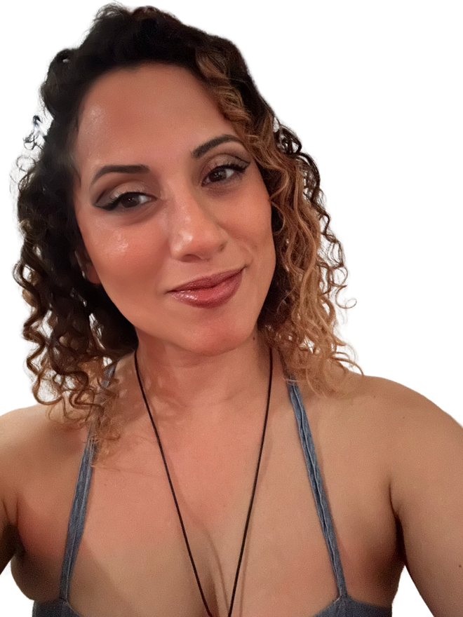 A woman with curly hair is wearing a necklace.