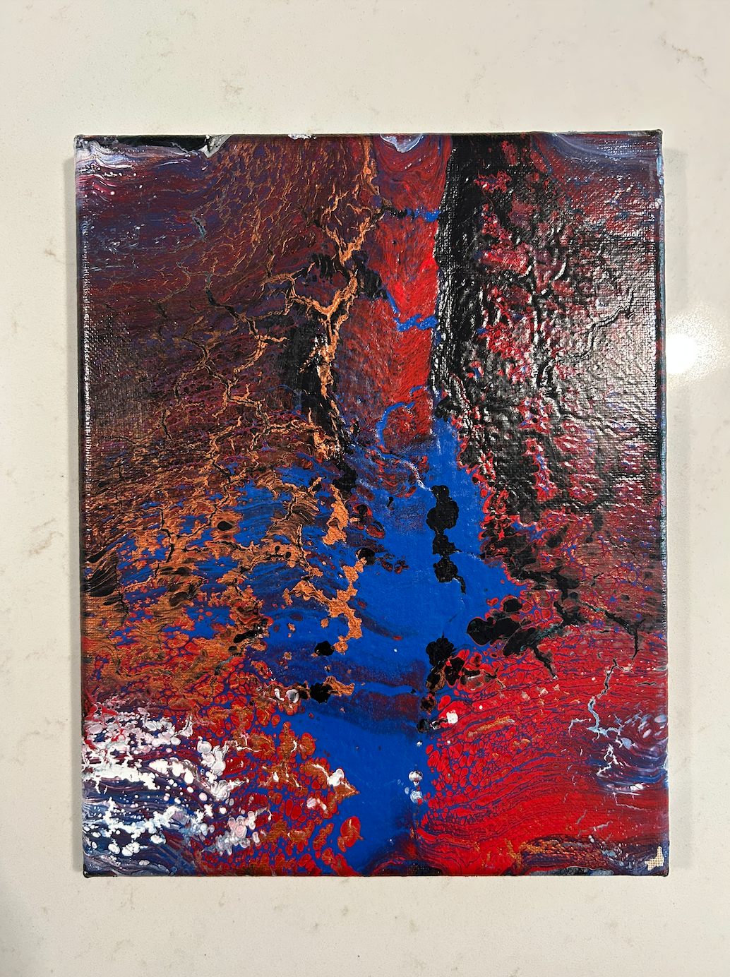 Abstract painting with blue, red, copper, and black colors on a textured surface.