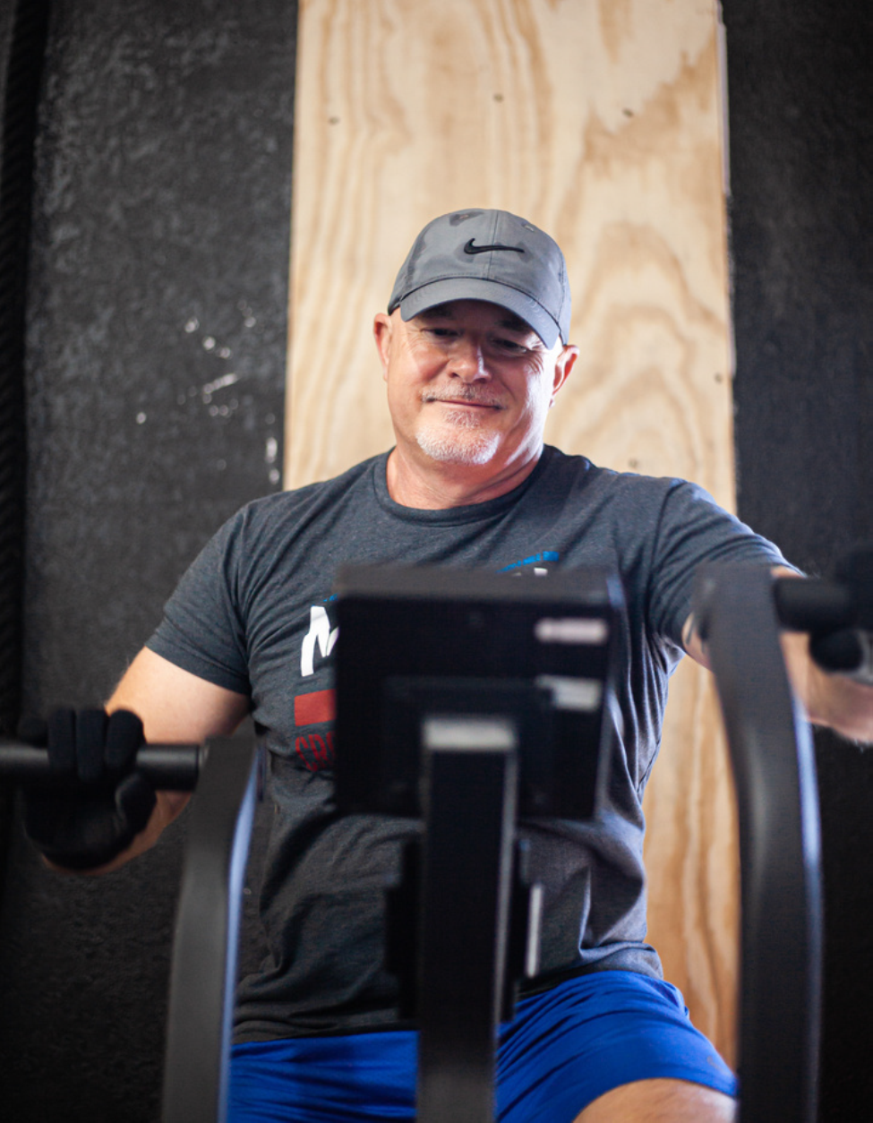 A man and a woman are posing for a picture and the woman is wearing a crossfit burleson shirt