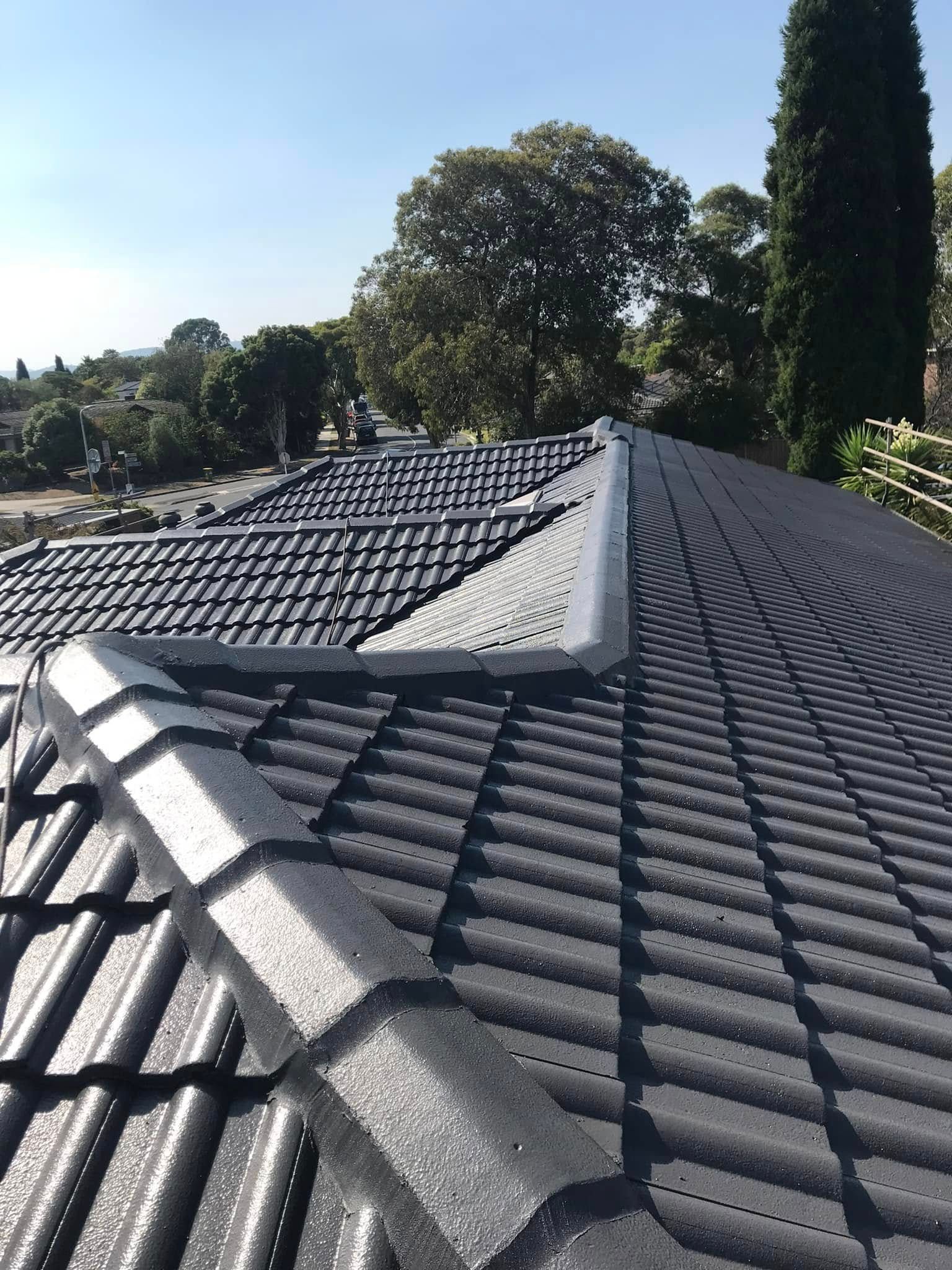 A close up of a roof with trees in the background.