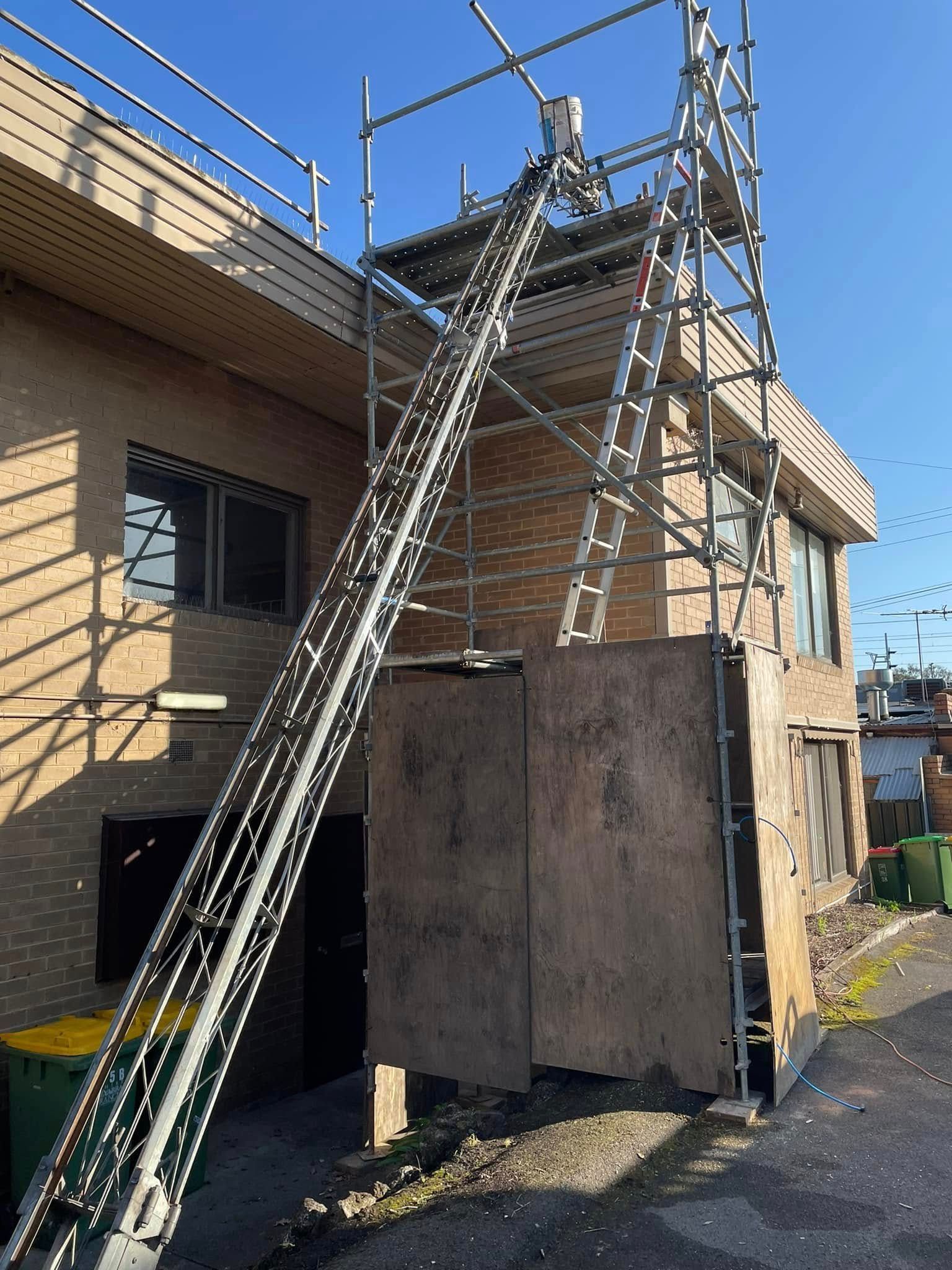 A ladder is attached to a scaffolding on the side of a building.