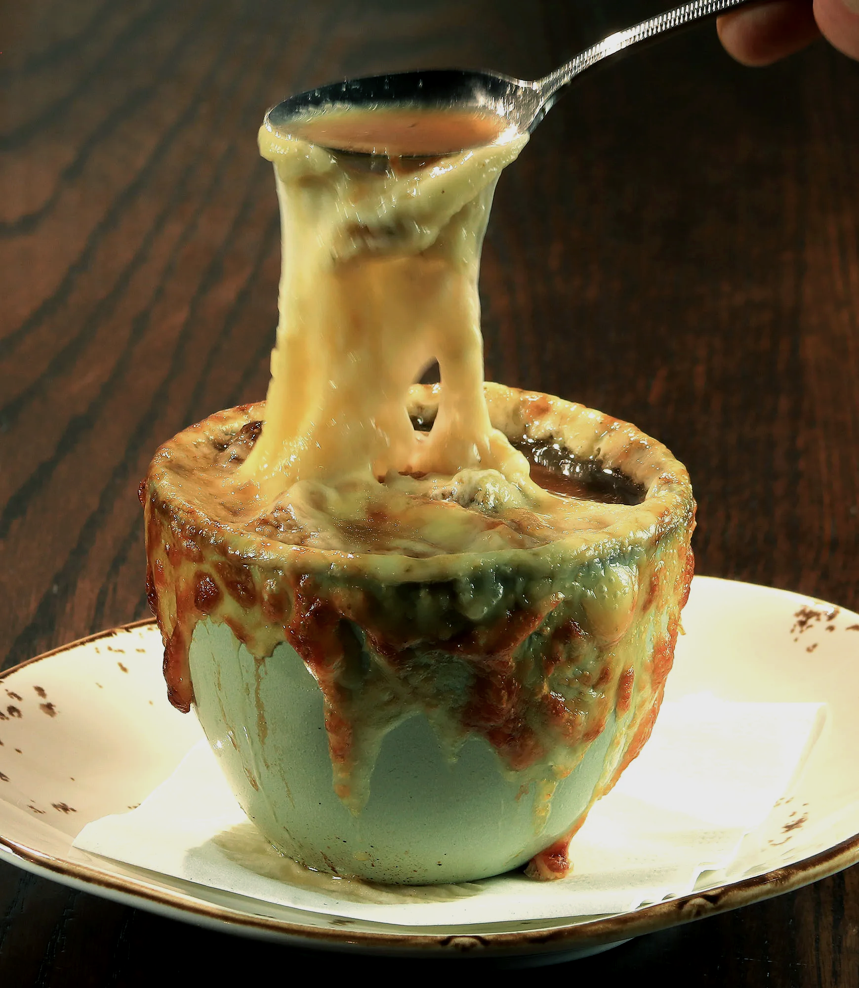 A bowl of soup with a spoon sticking out of it