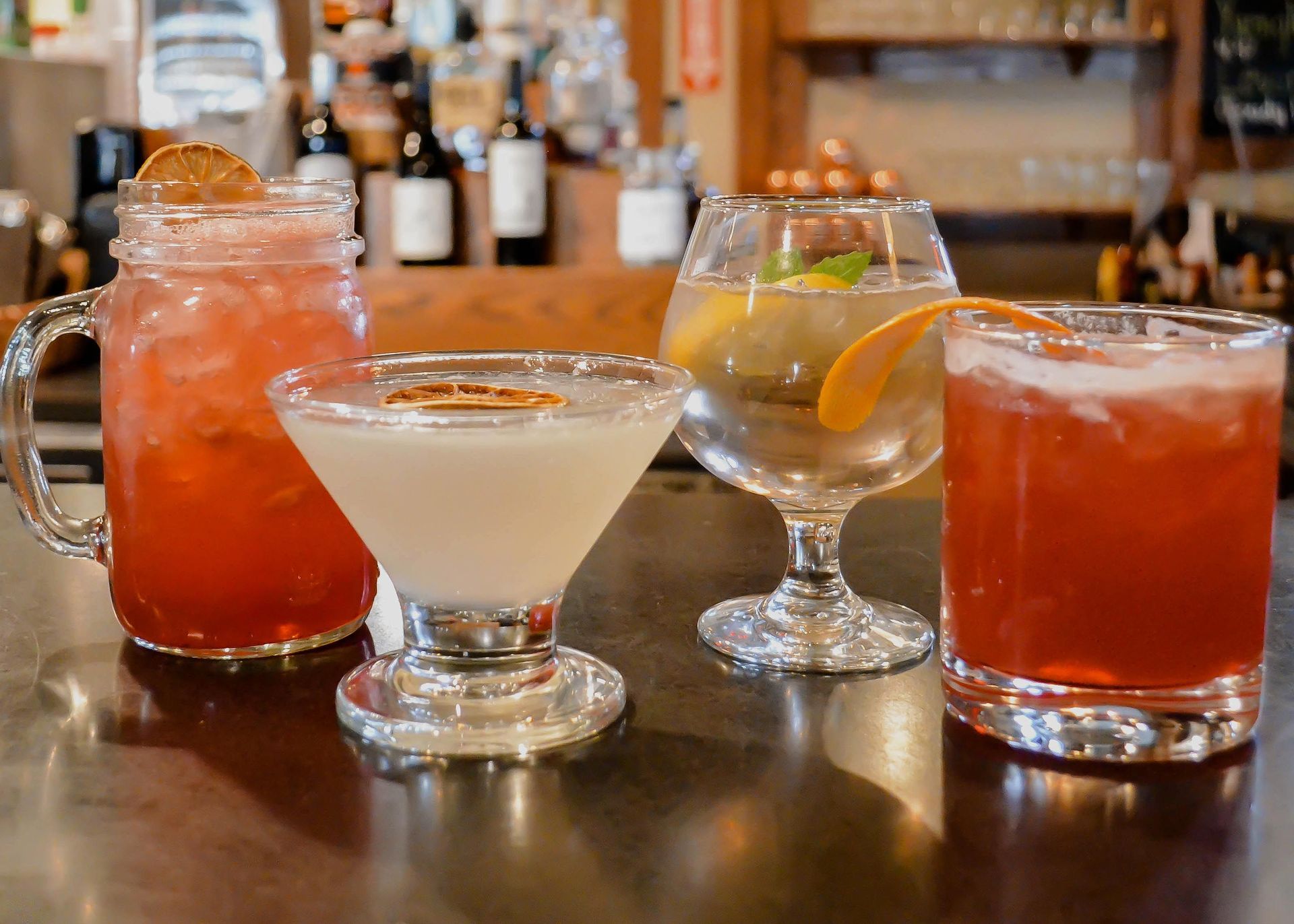 A table topped with four different types of drinks.