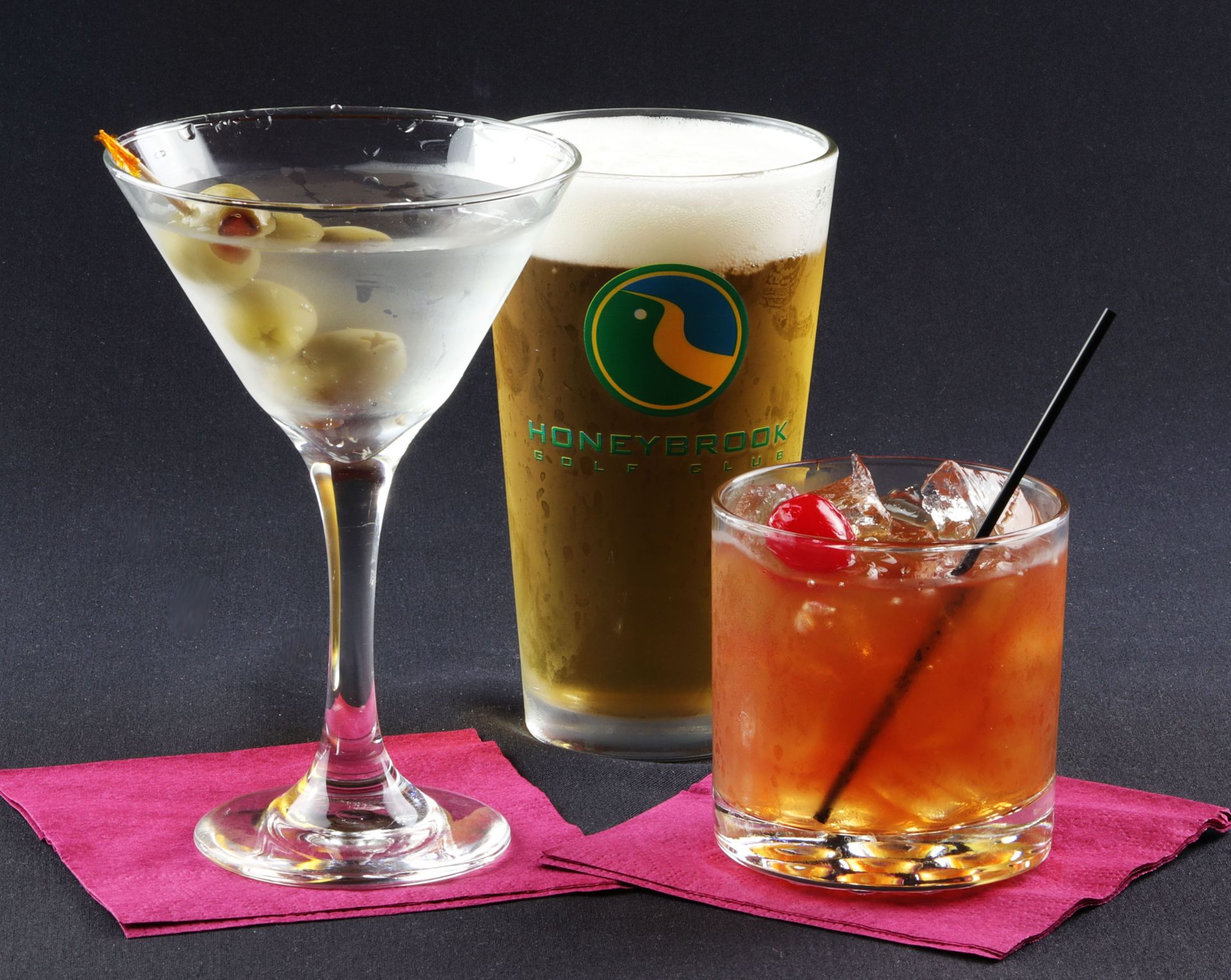A martini a beer and a cocktail on a napkin