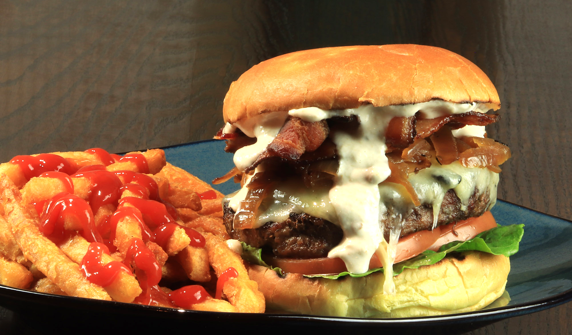 A hamburger and french fries on a blue plate