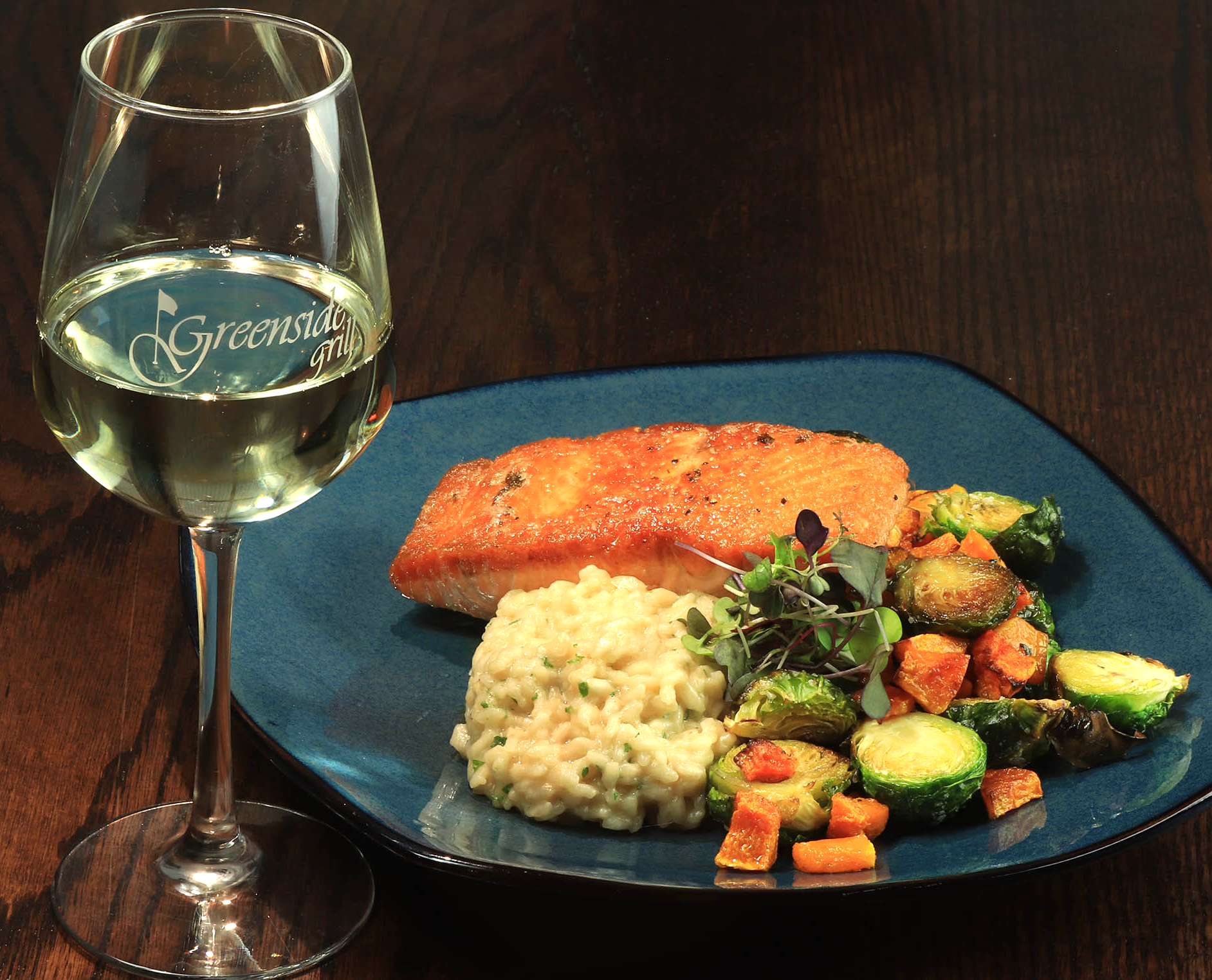 A plate of food next to a glass of wine that says greenway