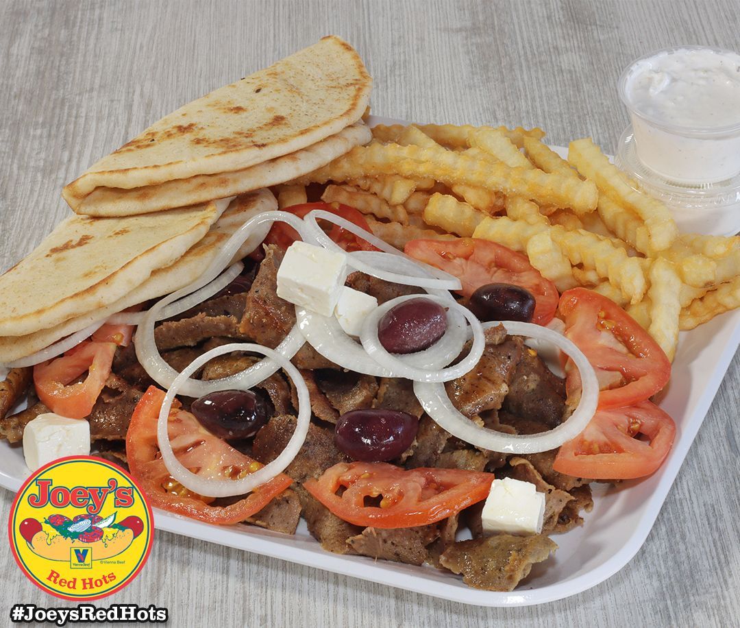 Gyro platter with meat, pita, fries, tomatoes, onions, olives, feta, and tzatziki.