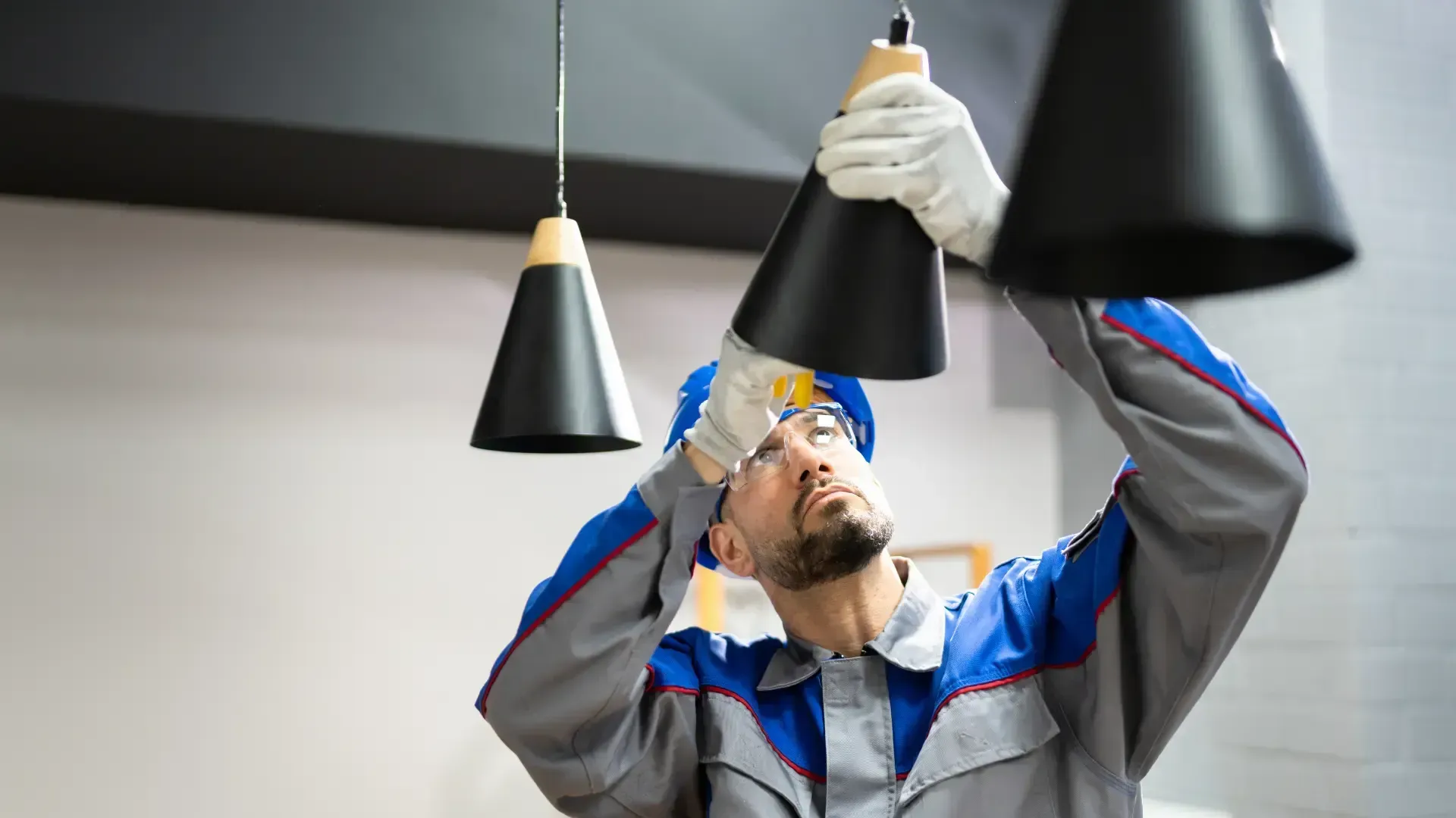 A man is installing a light fixture in a room.