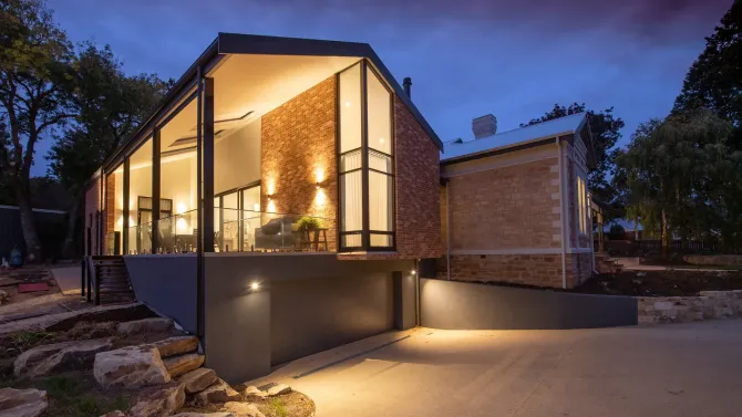 A large house with a lot of windows is lit up at night.