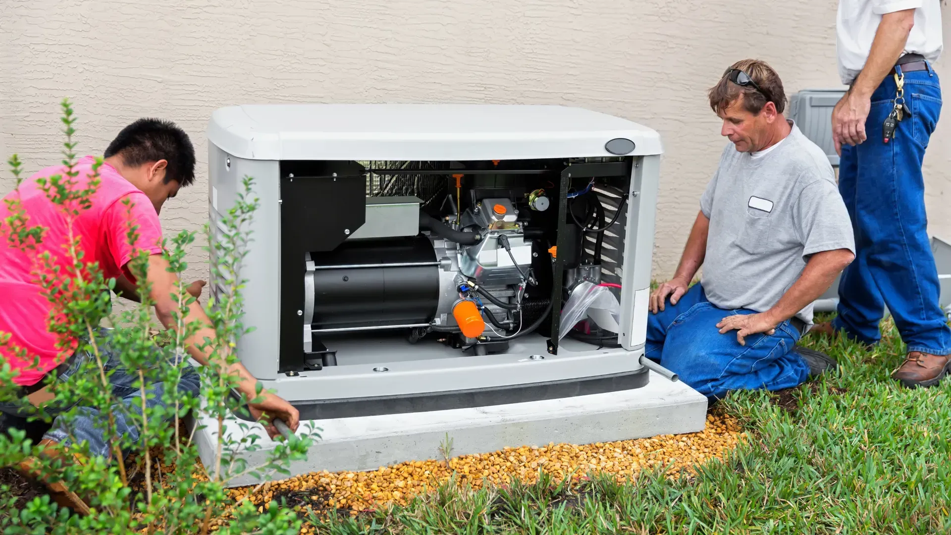 Two men are working on a generator outside of a building.