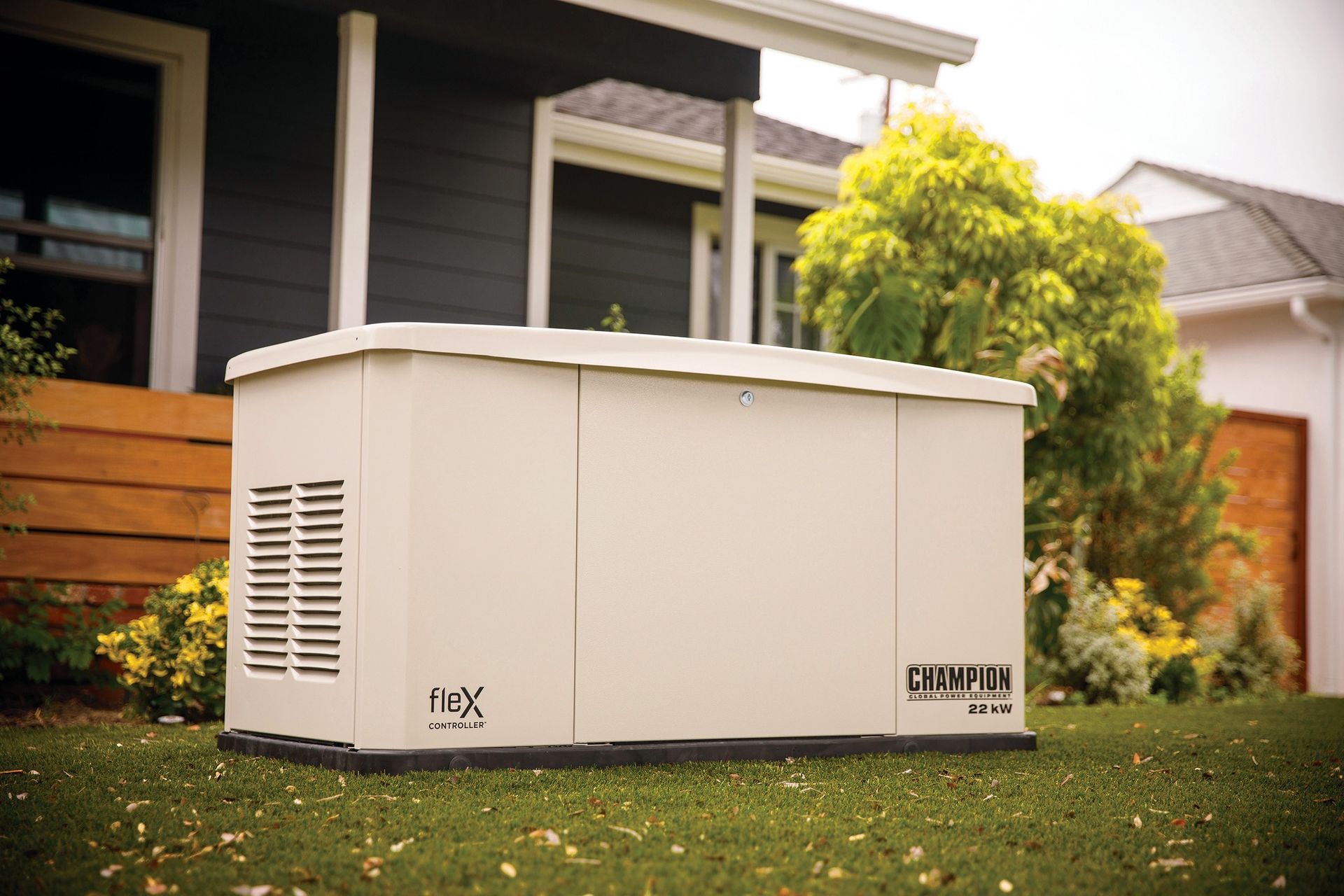 A generator is sitting in the grass in front of a house.