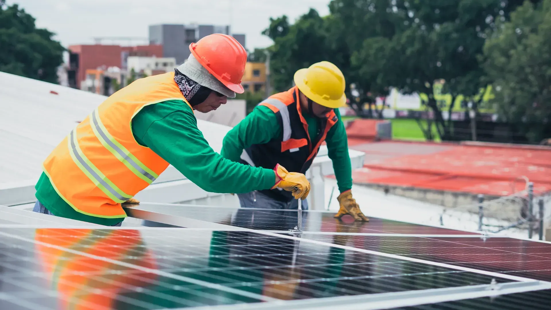 Two men are working on a solar panel on a roof.