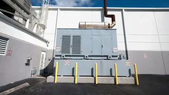 A large gray box with a smoke stack on the side of a building
