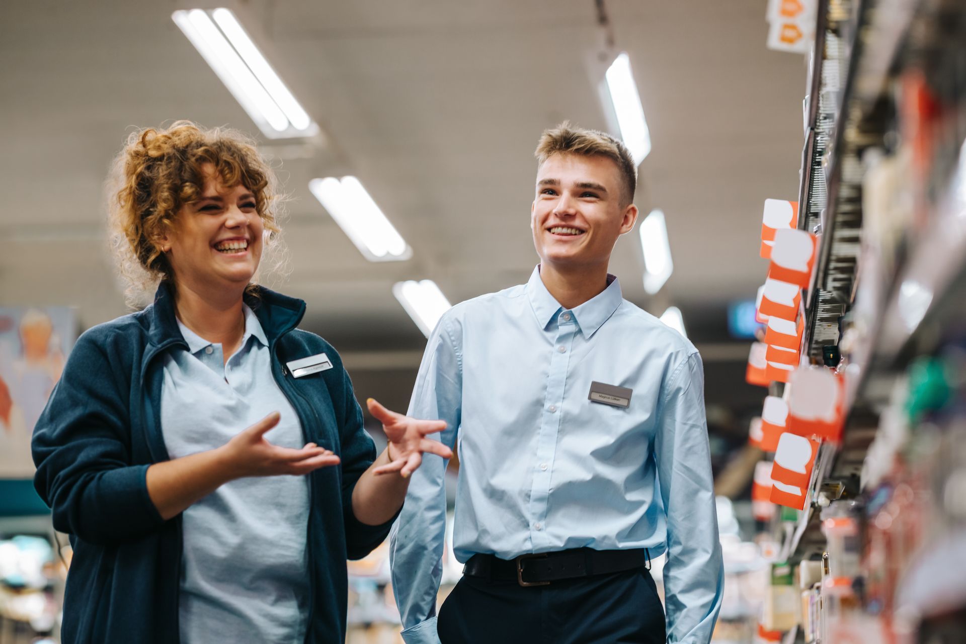 Supermarket manager laughing with an employee at the store.