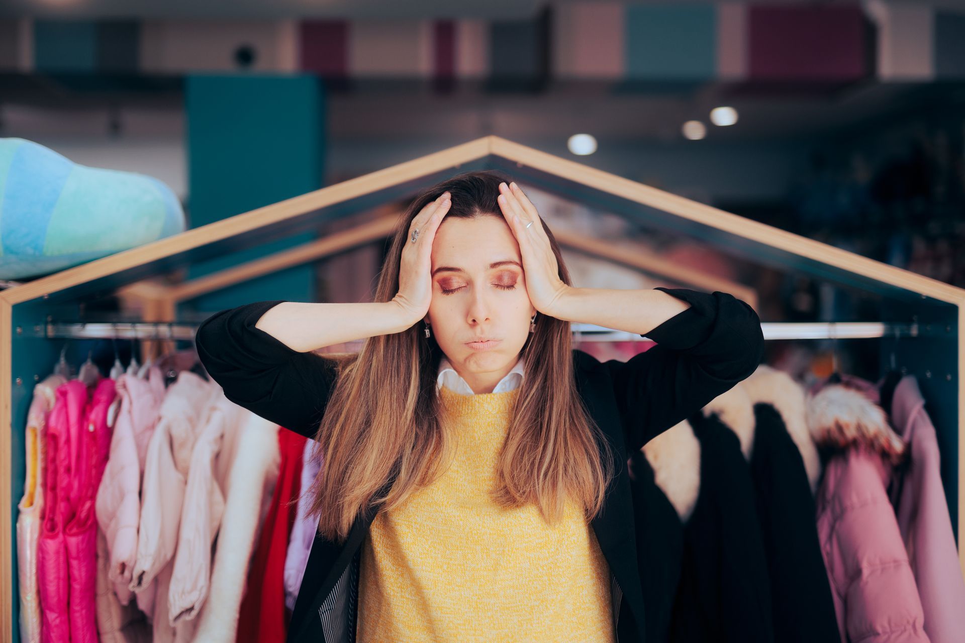 Worried business owner holding her hands to her head at a clothing store.