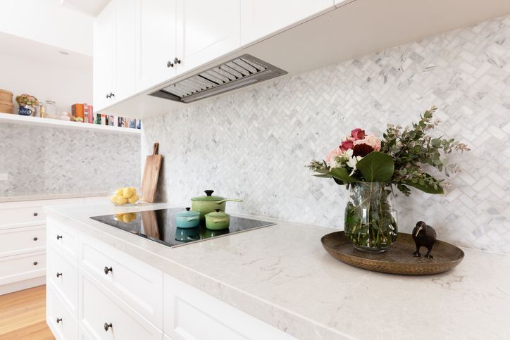 Modern white kitchen with marble backsplash showcasing high-end commercial fitout design.
