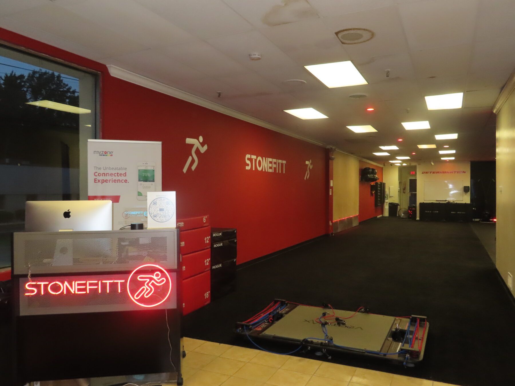 A gym with a red wall and a sign that says stonefit