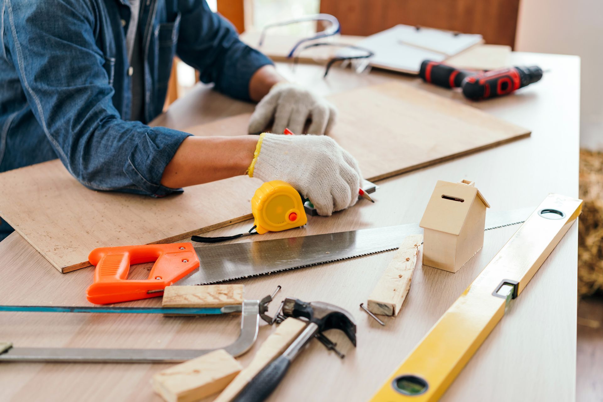 A man is cutting a piece of wood with a saw.