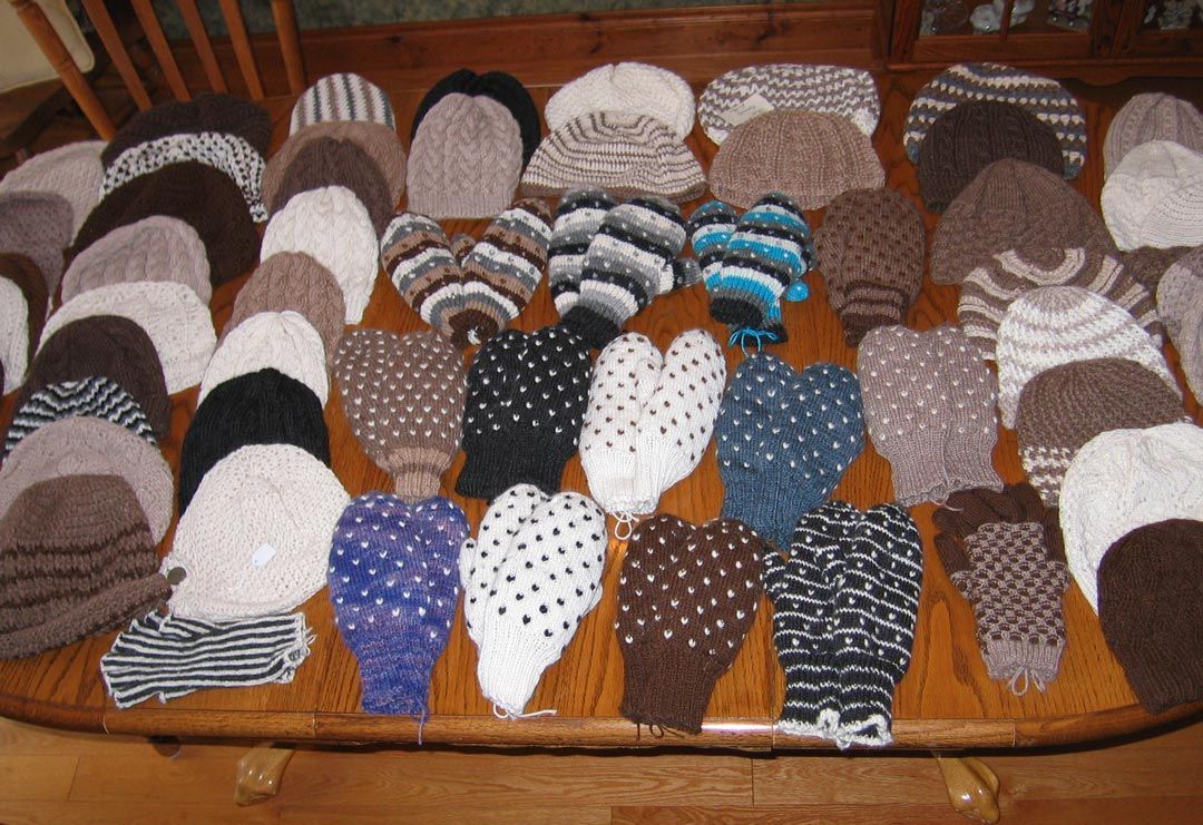 Alpaca mittens and hats on a table.