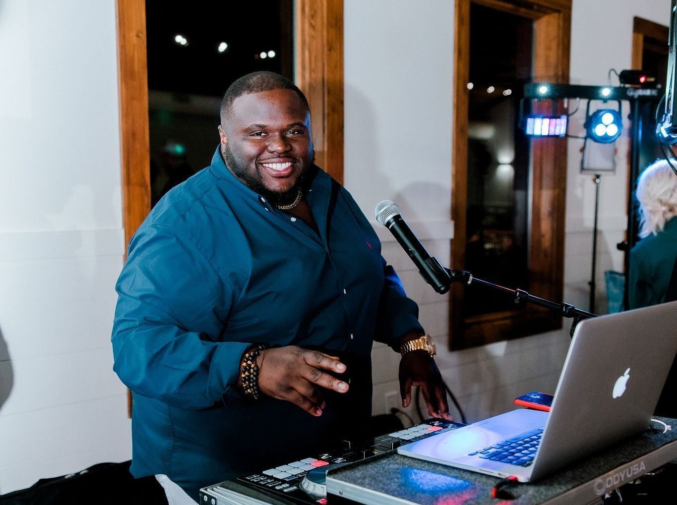 a man is standing in front of a laptop computer and a microphone .