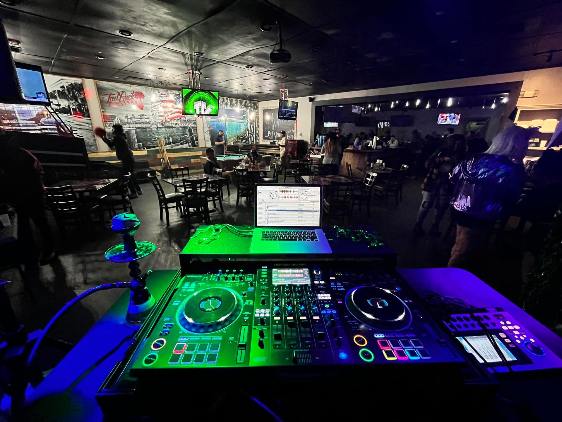 a dj booth in a restaurant with a laptop on it .