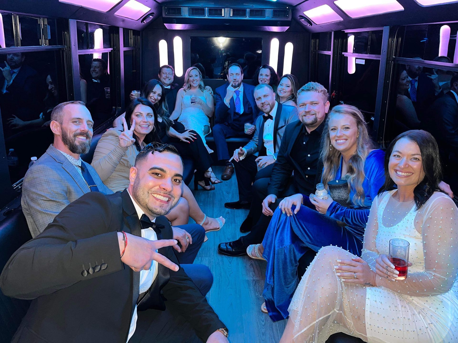 a group of people are sitting in a limousine party bus in Charleston, SC .