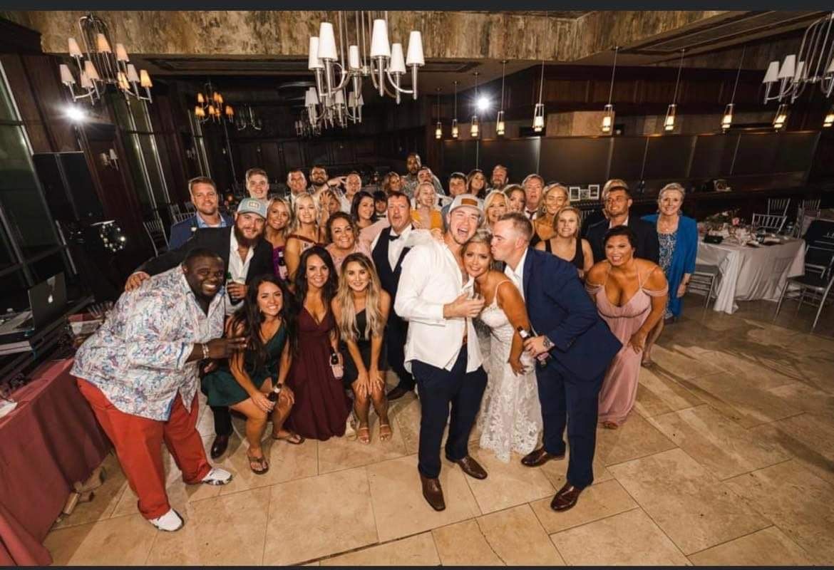 a group of people are posing for a picture at a wedding reception .