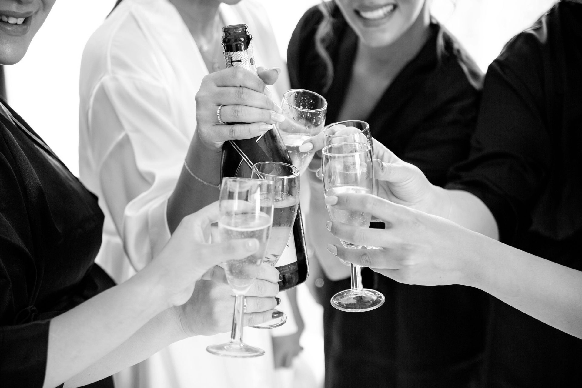 People toasting with champagne glasses; pouring from a bottle.