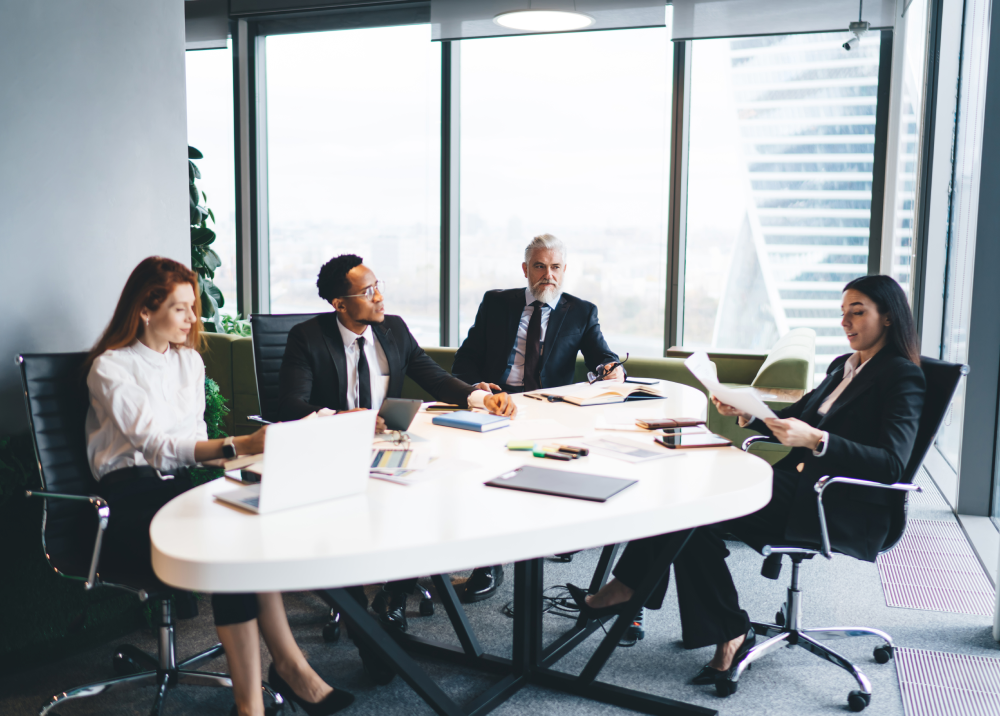 A group of business people are sitting around a table having a meeting.