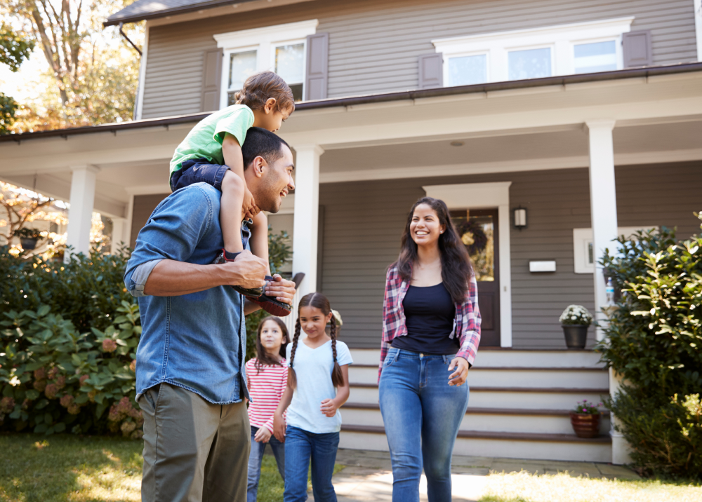 A family is walking in front of their house.