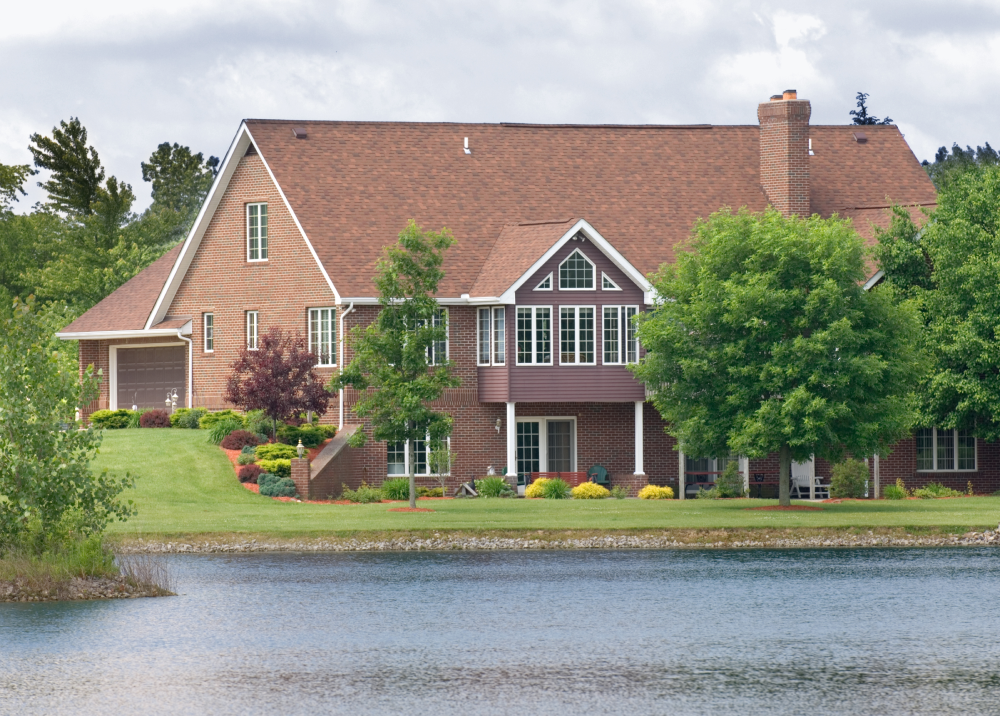 A large house sits next to a body of water