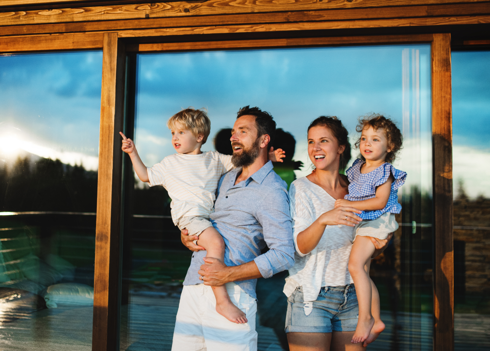 A family is standing in front of a sliding glass door.