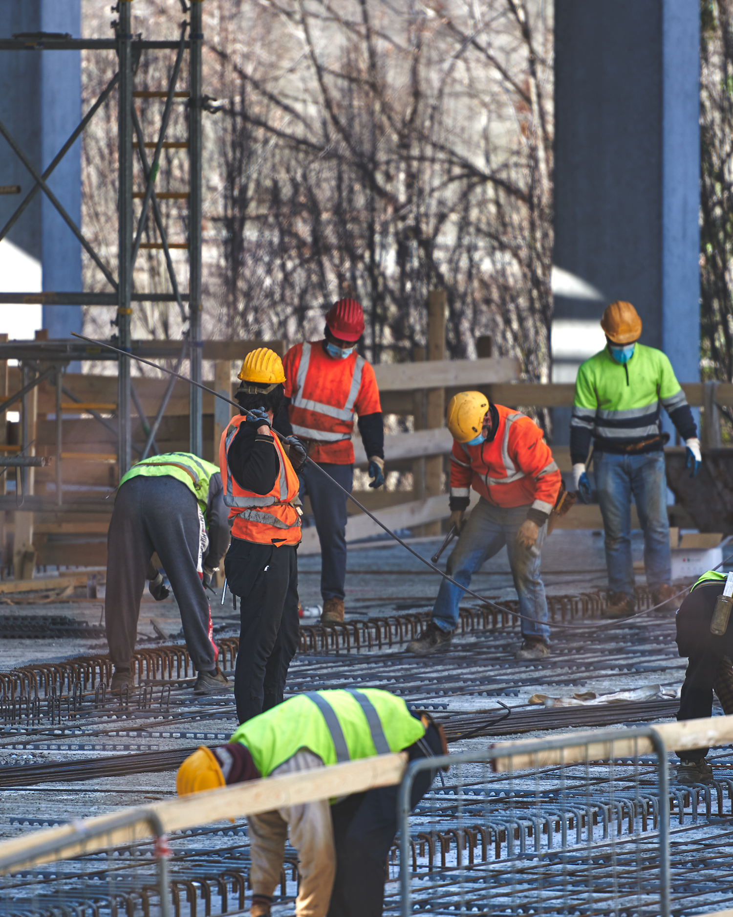 A group of construction workers wearing hard hats and safety vests