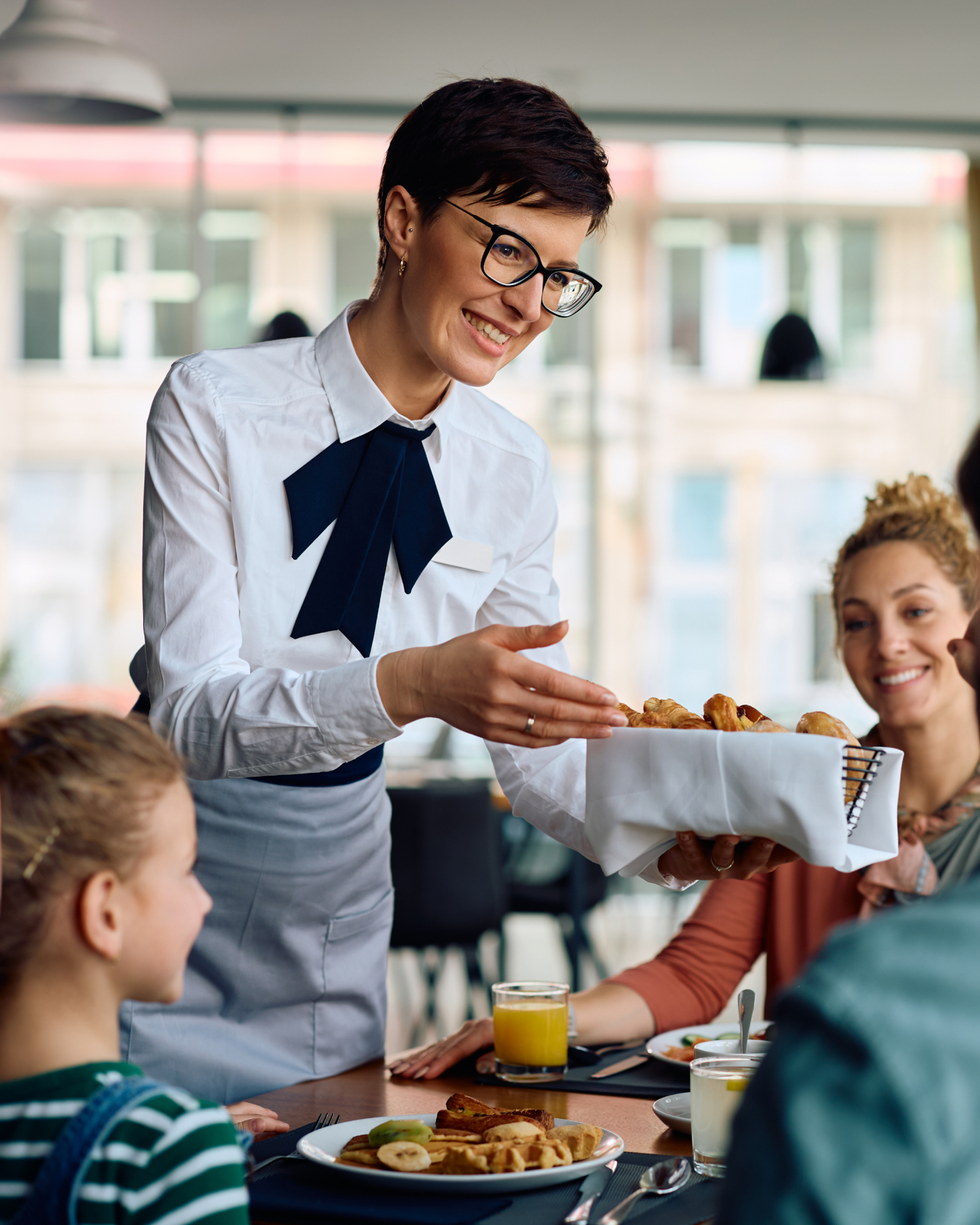 A waitress is serving food to a family in a restaurant.