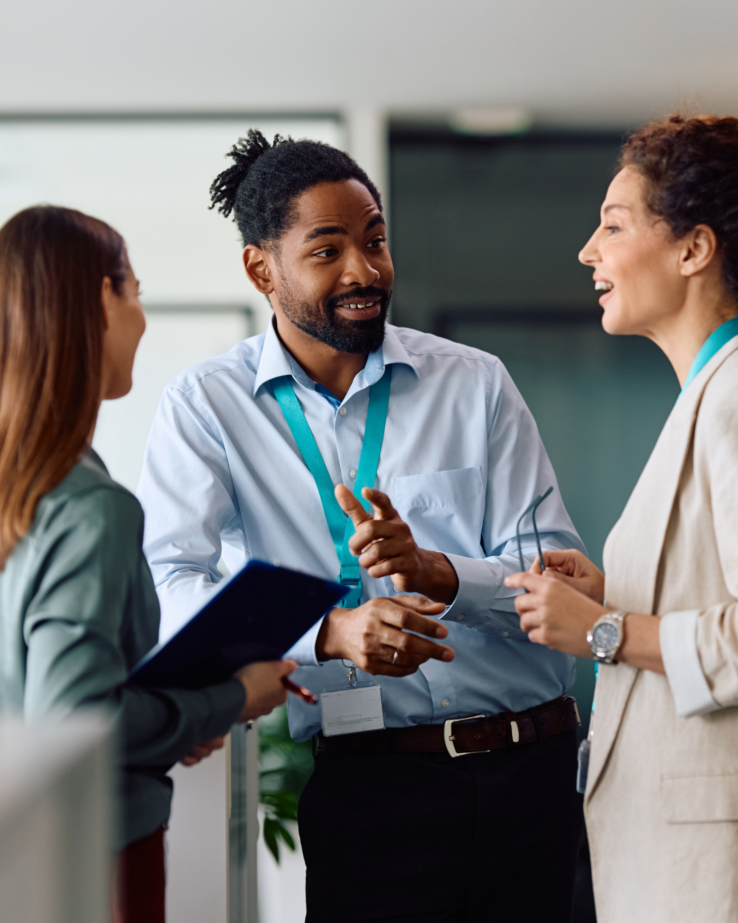 A man and two women are talking to each other in an office.