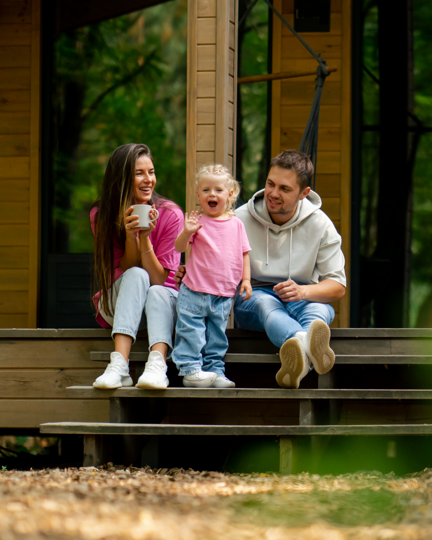 A family is sitting on the porch of a wooden house.